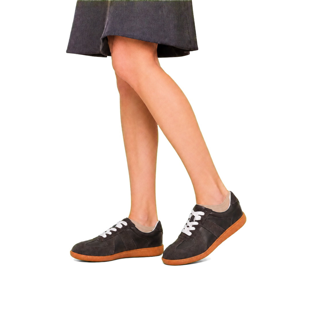 Harrow &amp; Quinn Nora Leather Sneakers in Onyx worn with a knee-length office skirt transparent background